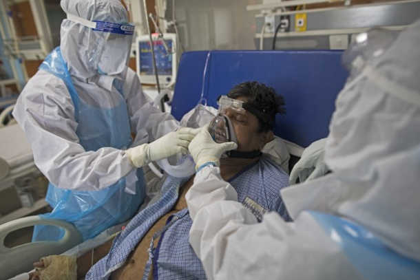 A doctor and nurse look after a coronavirus patient at Sharda Hospital in Greater Noida. 