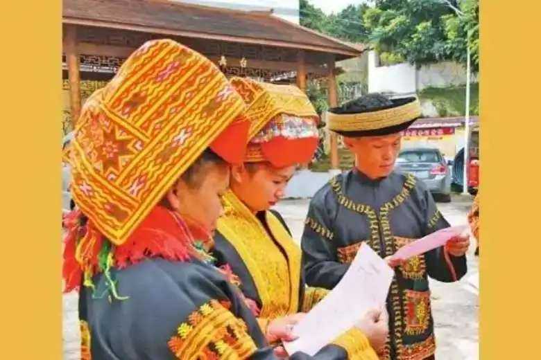 Ethnic Mien villagers in Guanxi province in China read a propaganda leaflet warning about the infiltration of illegal religions. (Photo: Weibo/Bitter Winter)