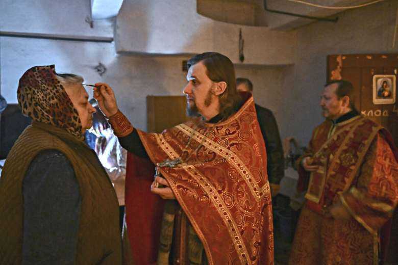 Orthodox priests pray with residents at a makeshift basement church at Lysychansk in the eastern Ukrainian region of Donbas on May 20