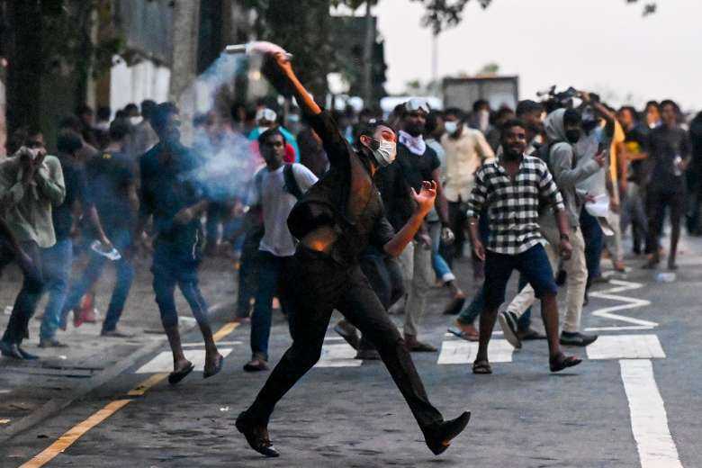 A demonstrator throws back a tear gas canister fired by police to disperse students taking part in a protest demanding the resignation of President Gotabaya Rajapaksa in Colombo on May 29