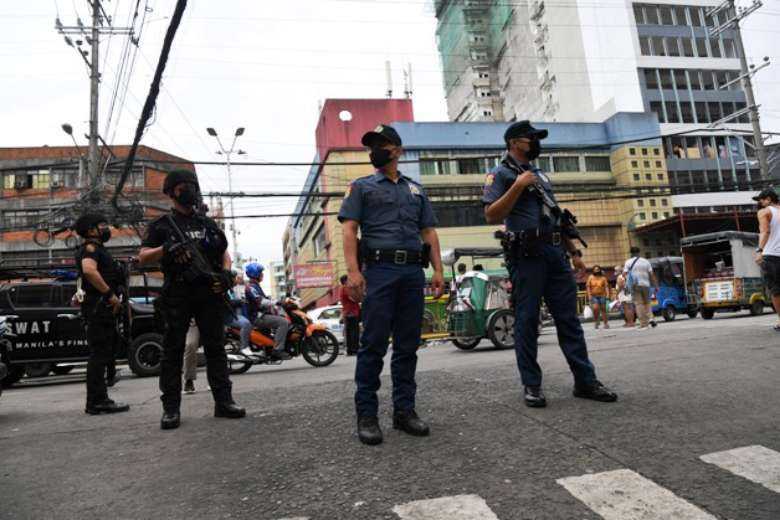 Policemen stand guard along a popular market street in Manila on June 1 following twin bombings in Basilan, near Jolo, a stronghold of Muslim militants