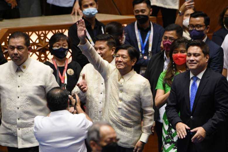 Philippine President-elect Ferdinand Marcos Jr. (center) waves to supporters as he arrives for his proclamation as president at the House of Representatives in Quezon City, suburban Manila, on May 25