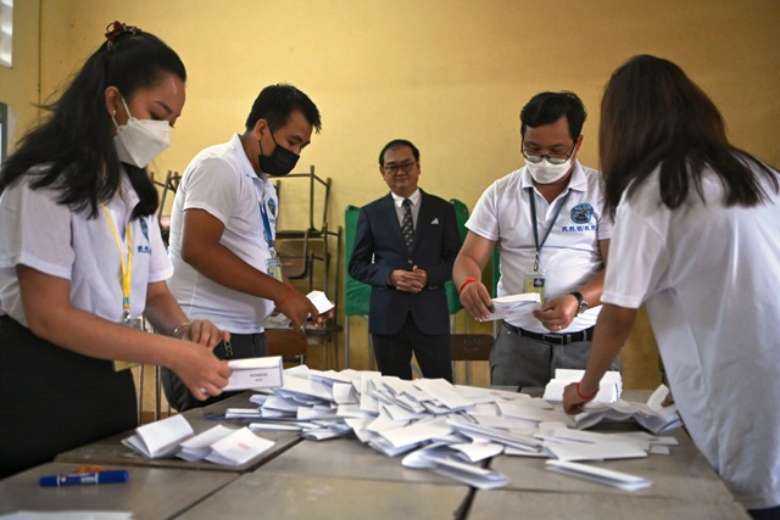 Cambodian election officials count ballots observed by Sovannarom Dim (center) of the National Election Committee at a polling station during the commune elections in Phnom Penh on June 5