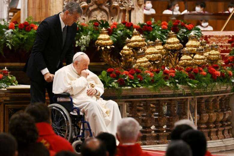 Aide Sandro Mariotti assists Pope Francis in a wheelchair during a Pentecost Mass at St. Peter's Basilica in the Vatican on June 5