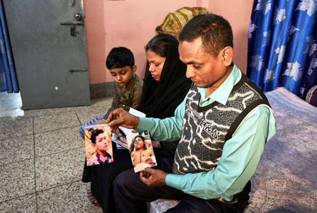 Mohsin Howlader (right), seen with his family at their house in Dhaka on Feb. 9, shows pictures of his 14-year-old son Rakib, who died while in police custody in 2018
