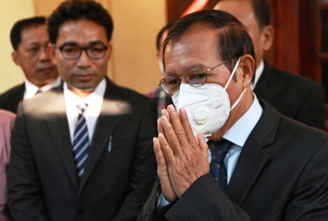 Kem Sokha (right), former leader of the now-dissolved Cambodia National Rescue Party, greets the media at his home before leaving for the resumption of his trial on treason charges in Phnom Penh on Jan. 19