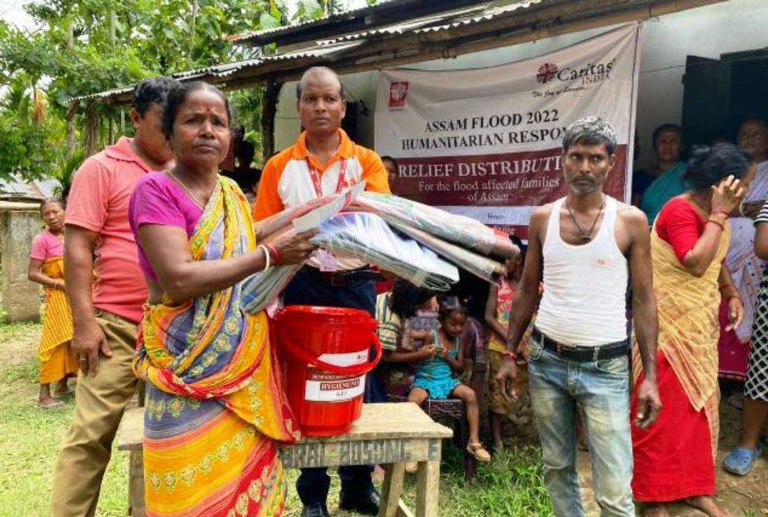 A Caritas India official distributes relief kits to flood-affected people in India's northeastern state of Assam on June 22