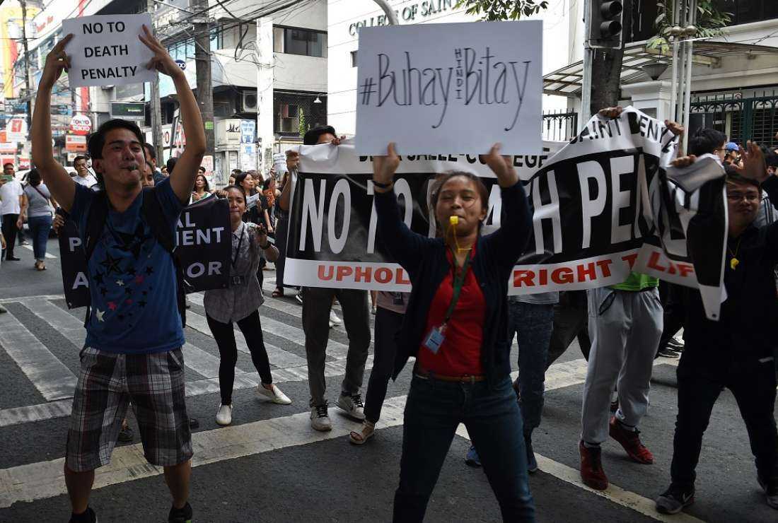 University students hold anti-death penalty placards during a rally in front of their school in Manila on March 8, 2017
