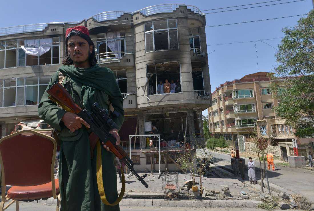 A Taliban fighter stands guard in front of a Sikh temple following an attack by gunmen in Kabul on June 18