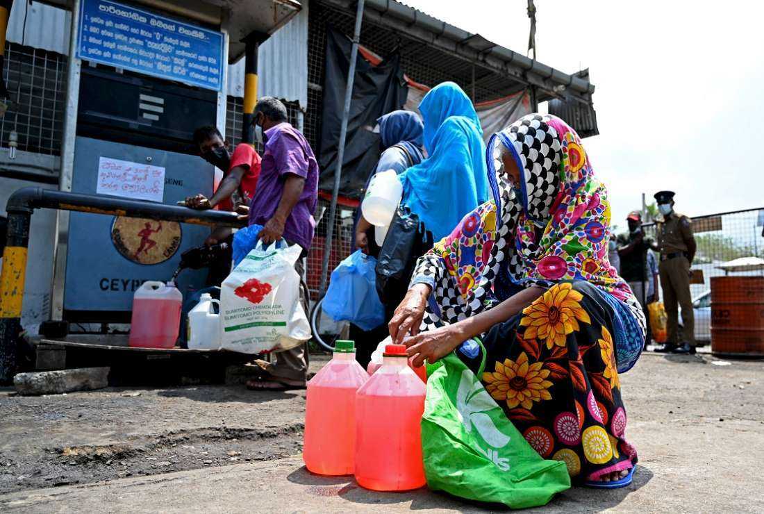 A woman buys kerosene for home use at a petrol station in Colombo on March 25 as Sri Lanka grapples with its worst economic crisis in decades