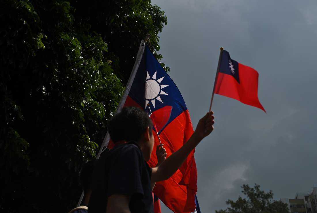 A man holds a Taiwanese flag during a flag-raising ceremony to mark the 108th anniversary of founding of Republic of China, in Tuen Mun District in Hong Kong on Oct. 10, 2019