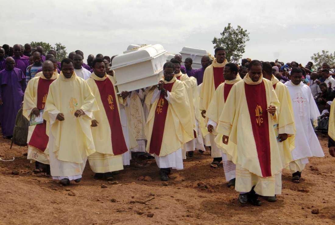 Clergymen carry white coffins containing the bodies of Catholic priests killed by Fulani herdsmen for burial at Ayati-Ikpayongo in Gwer East district of Benue State, Nigeria, on May 22