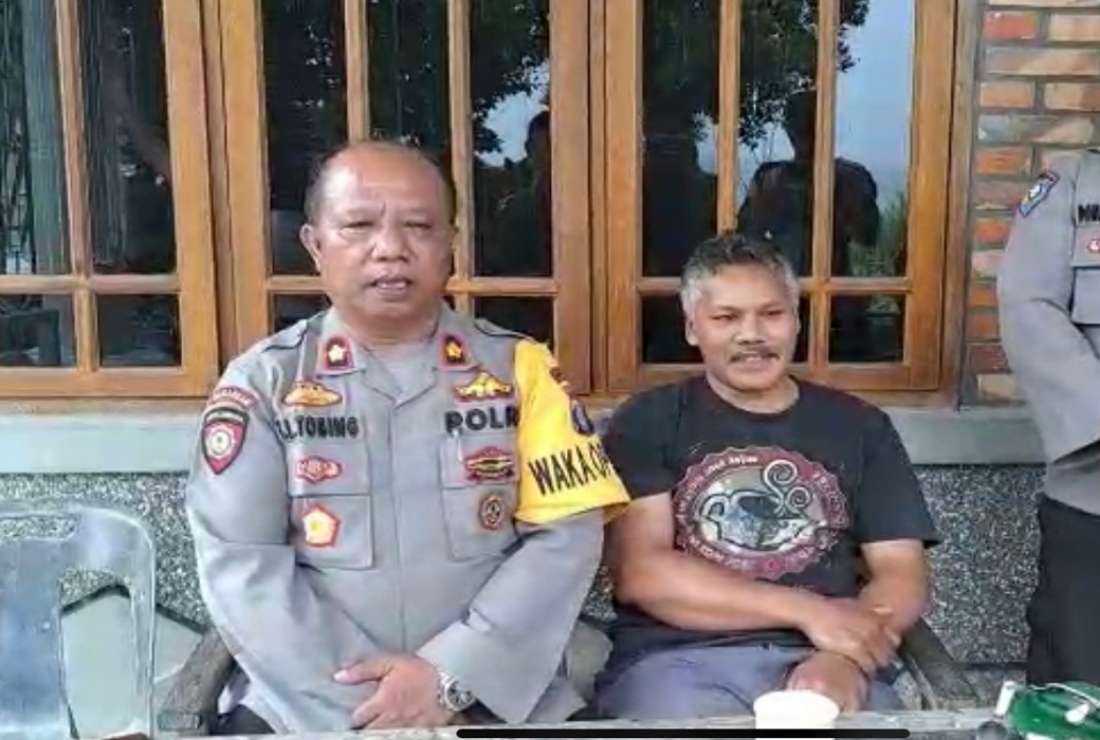 Togap M. Lumbantobing (left), deputy police chief in Tomok district, North Sumatra province, sits with Capuchine Father Sabat Saulus Nababan as he issues a public apology for berating the priest