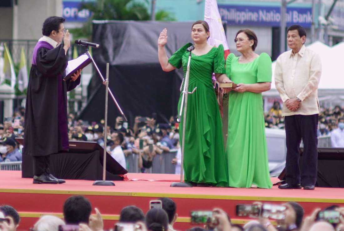 Philippines' Vice President-elect Sara Duterte takes her oath before Supreme Court associate justice Ramon Hernando (left) and her mother Elizabeth Zimmerman and outgoing president Rodrigo Duterte during the inauguration ceremony in Davao City on June 19
