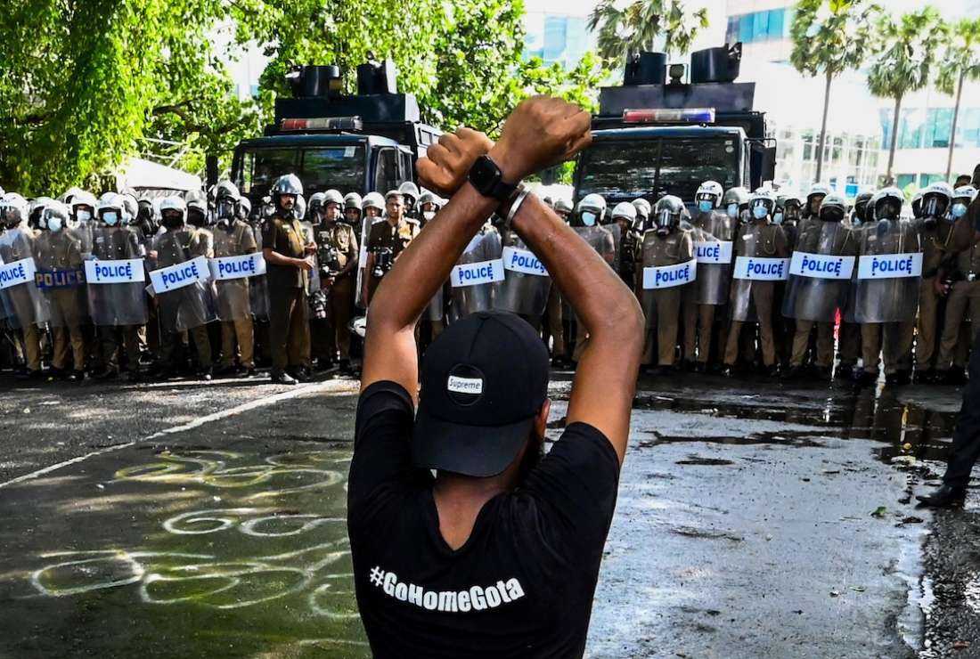 A student gestures in front of riot police during a demonstration demanding the resignation of Sri Lanka's President Gotabaya Rajapaksa over the country's crippling economic crisis in Colombo on May 21