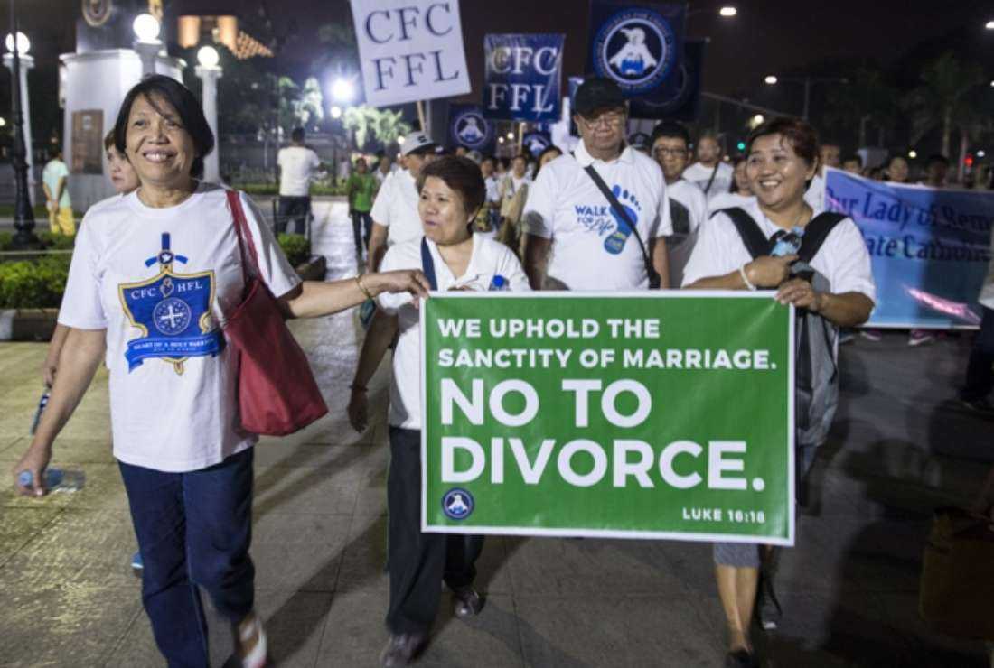 Philippine Catholic faithful hold a banner against absolute divorce as they take part in a 