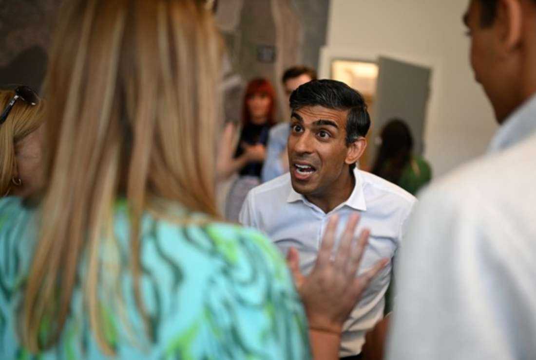 Conservative MP and Britain's former chancellor of the exchequer, Rishi Sunak, (center) talks to activists and supporters as part of his bid to become the next leader of the Conservative party during a visit to Teesside Freeport in Redcar, northeast England, on July 16
