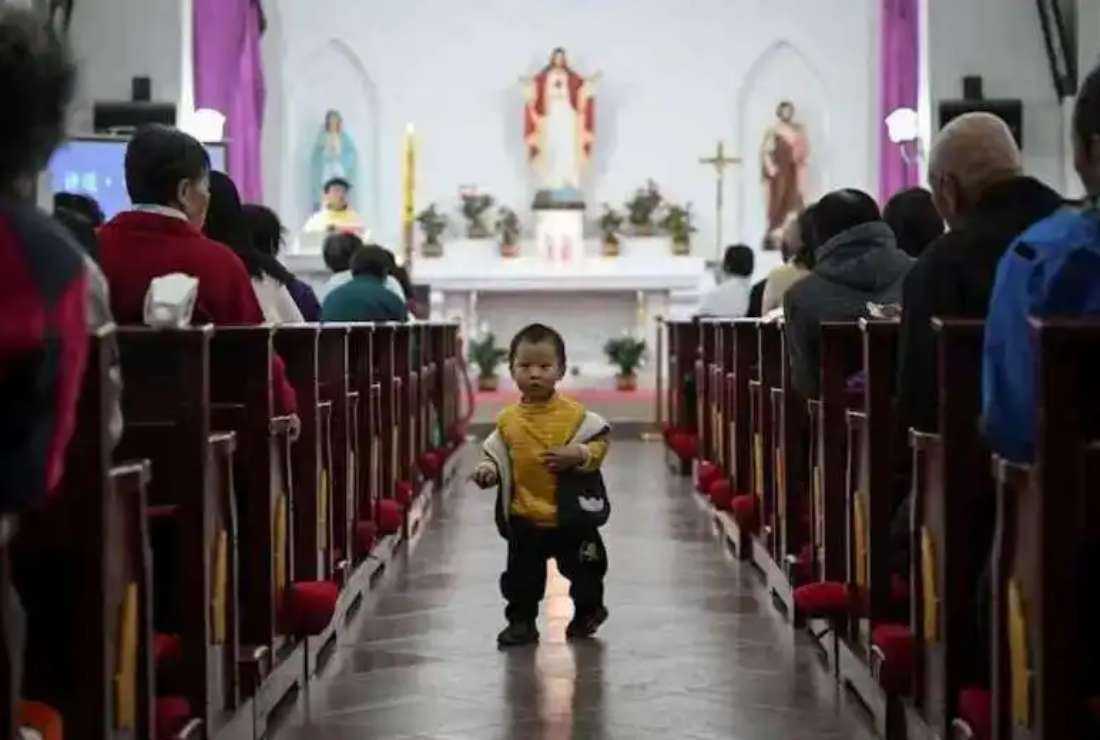 A Chinese boy walks down the aisle during a Mass at a Catholic church in a village near Beijing on Holy Saturday, April 3.
