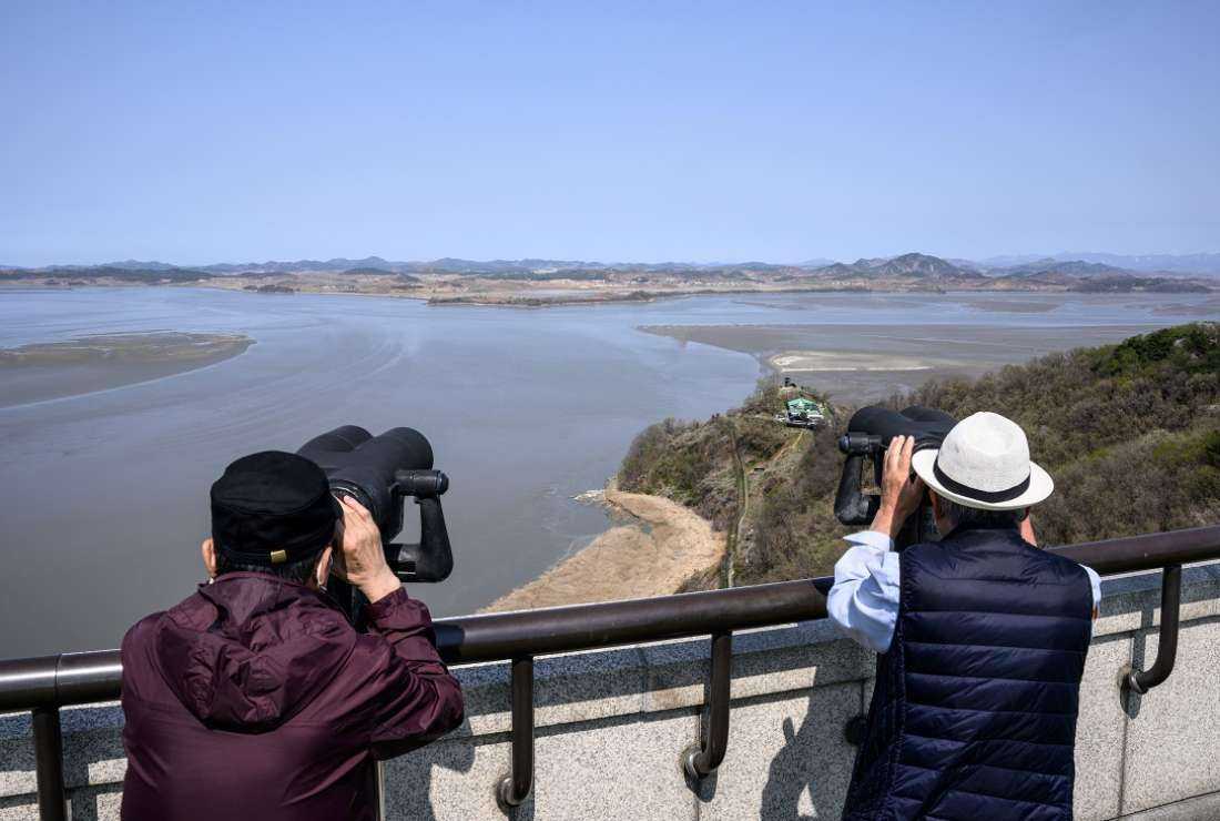 Visitors use binoculars to look towards the North Korean side of the Demilitarized Zone from the Odusan Unification Tower in Paju on April 15
