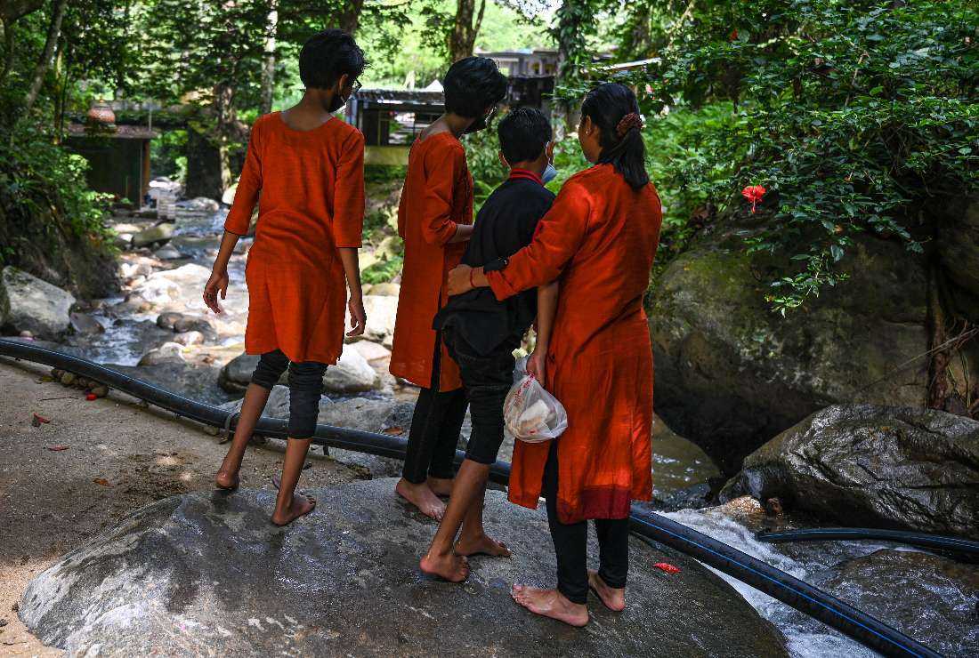 Loh Siew Hong (right) hugging her son next to her other children by a river in Gombak, Malaysia's Selangor state, in this picture taken on May 30