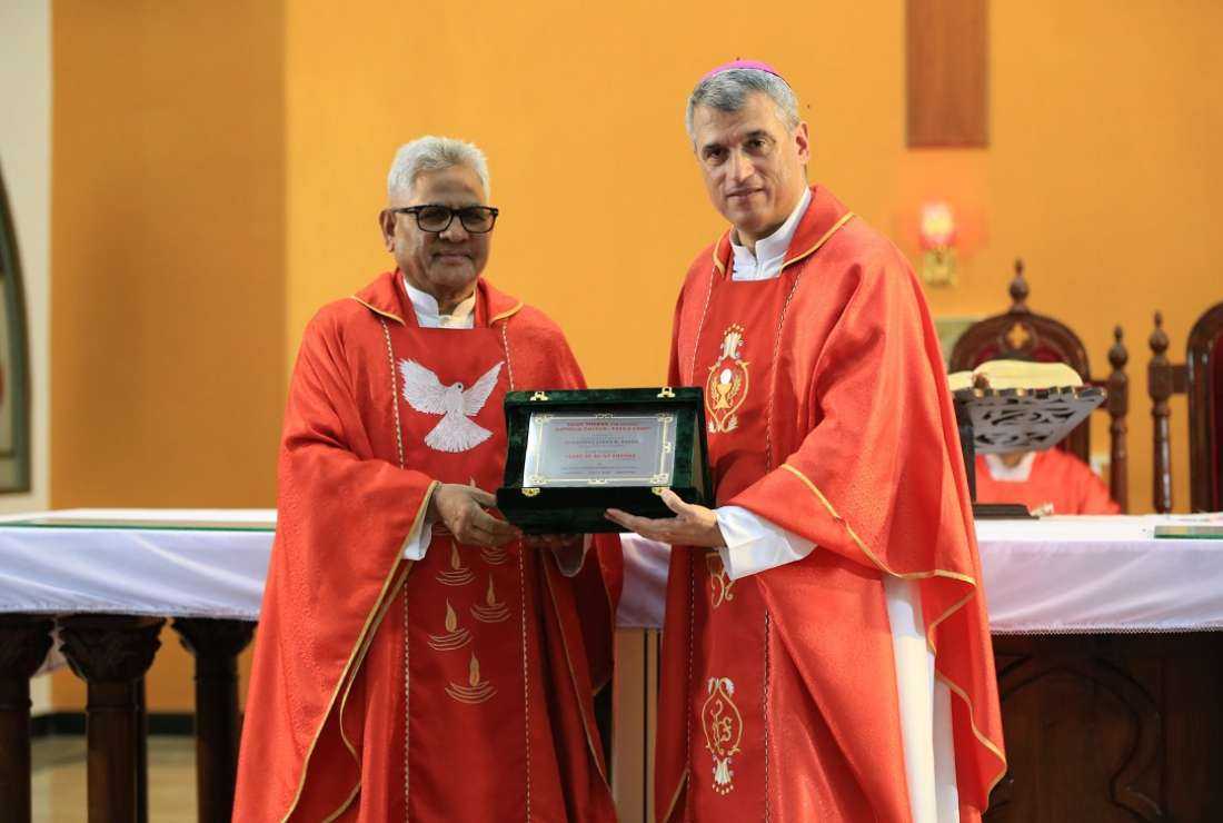 Father James Shamaun presents a shield of appreciation to Archbishop Christophe Zakhia El-Kassis, the apostolic nuncio to Pakistan, on July 4