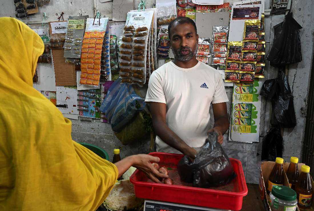 A shopkeeper Mohamad Faizal speaking while tending to his store in the Slave Island neighbourhood of Colombo