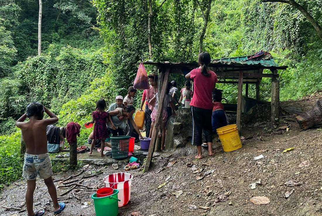 This picture taken on Sept 24, 2021 shows refugees collecting water at Pang village in India's eastern state of Mizoram near the Myanmar border, after people fled across the border following attacks by Myanmar's military on villages in western Chin state