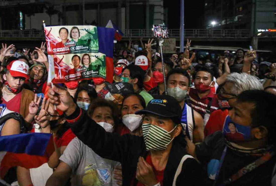Supporters of Philippine presidential candidate Ferdinand Marcos Jr. celebrate outside his campaign headquarters after his landslide presidential election victory, in Mandaluyong City, Metro Manila, on May 11