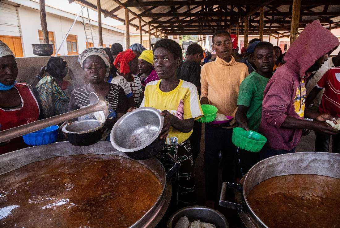 Refugees from the Democratic Republic of Congo (DRC) receive lunch at the Nyakabande Transit Center in Kisoro, Uganda, on June 7