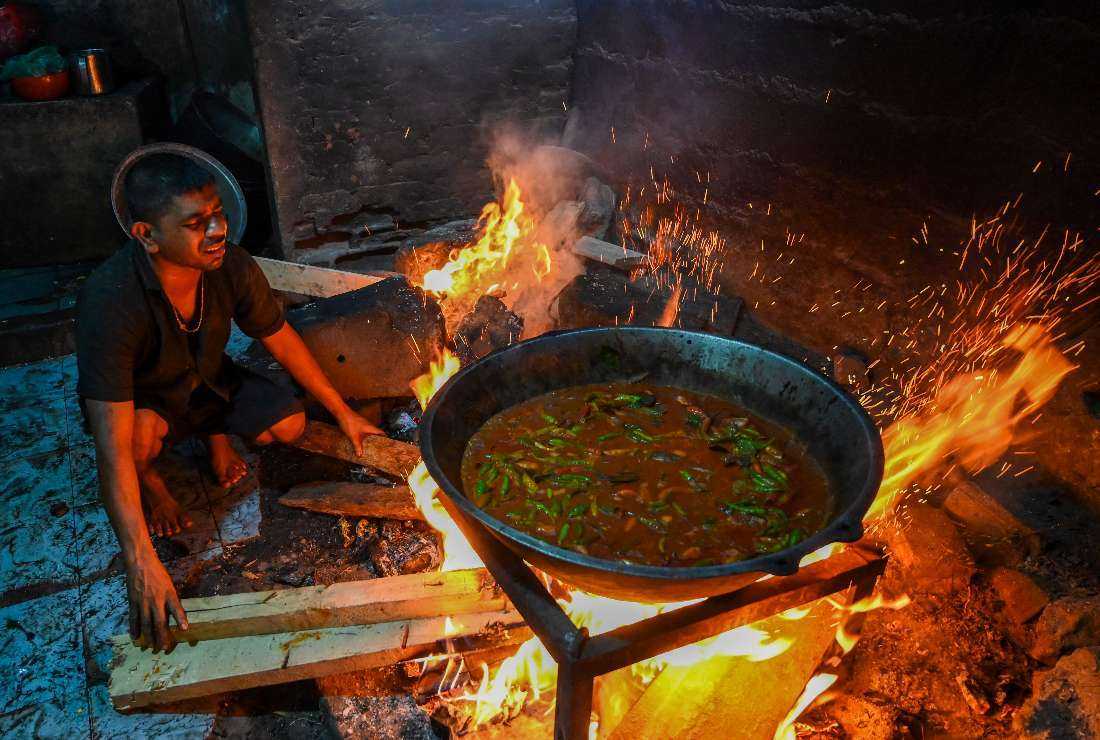 A man uses firewood to cook food at a hotel in Colombo