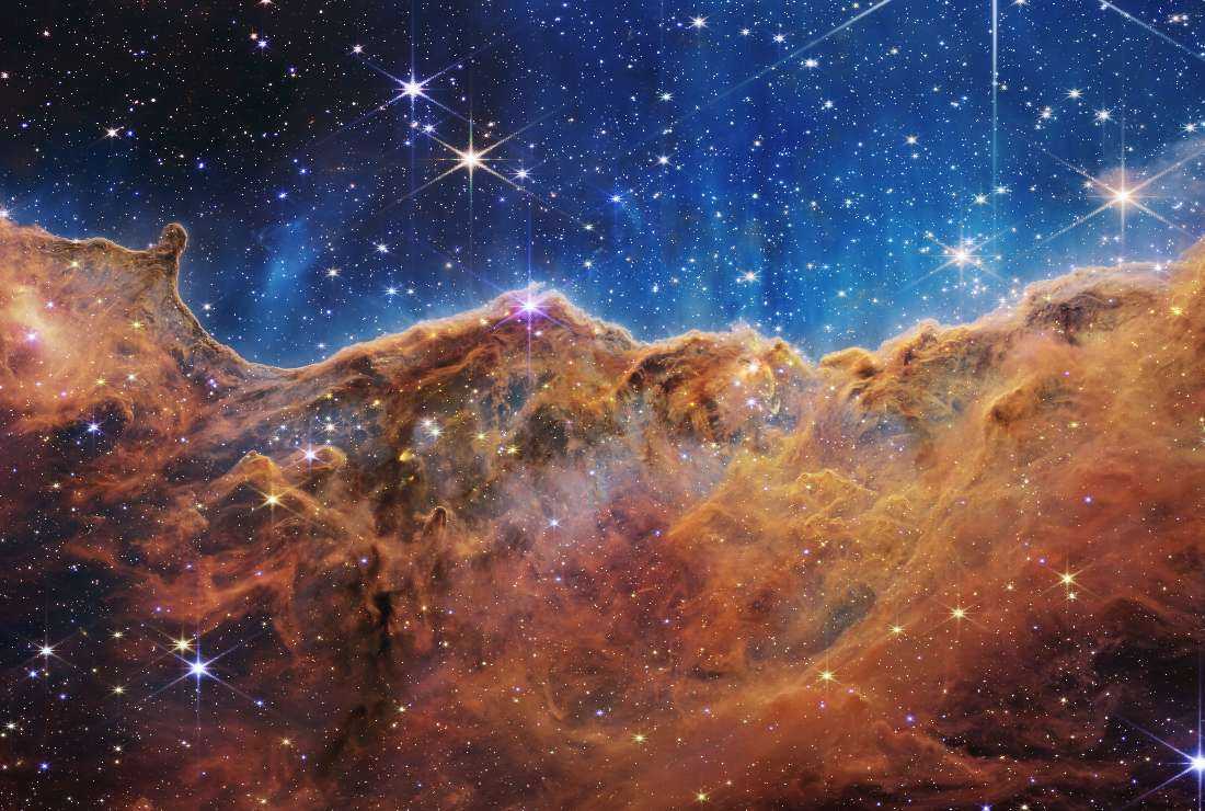 This image released by NASA on July 12 from the James Webb Space Telescope (JWST) shows a landscape of mountains and valleys speckled with glittering stars which is actually the edge of a nearby, young, star-forming region called NGC 3324 in the Carina Nebula