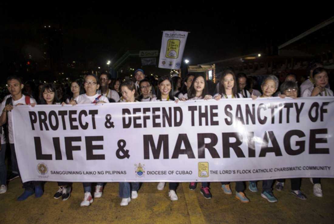 Philippine Catholic faithful holding a banner as they take part in a Walk for Life protest at a park in Manila, on Feb