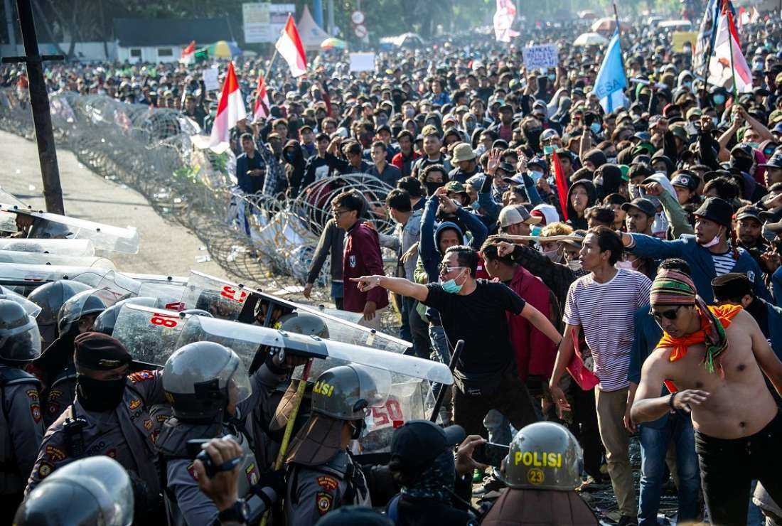 Protesters, right, confront police outside the local parliament building in Surabaya on Sept 26, 2019, during a rally against the government's proposed change in its criminal code laws