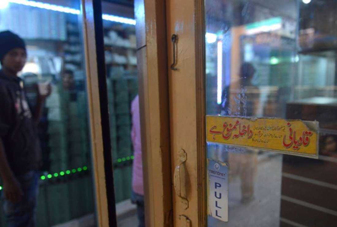 A Pakistani man looks at a poster displayed outside a shop banning Ahmadi customers from entering at a market in Lahore on Dec. 14, 2015