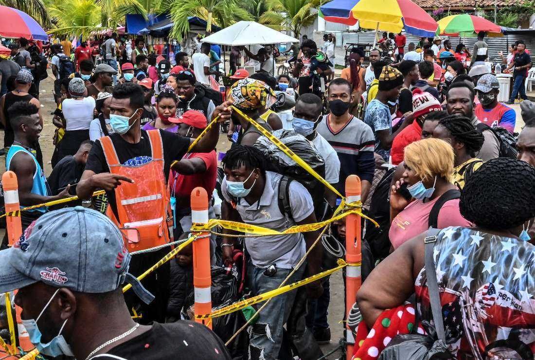 Stranded migrants from Cuba, Haiti, Venezuela and several African countries enter the port to board a boat to leave Necocli, Colombia, on July 30, 2021