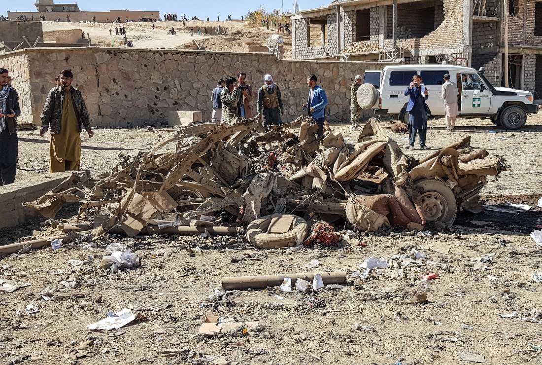 Security personnel and residents gather around the site of a car bomb attack that targeted an Afghan police headquarters in Feroz Koh, the capital of Ghor Province on Oct. 18, 2020