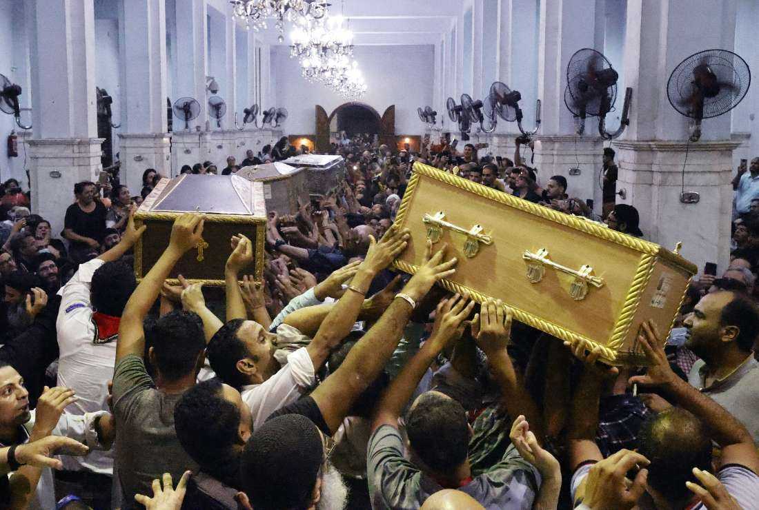 Egyptian mourners carry the coffin of Ibram Tamer Wageh (right), a boy killed in a Cairo Coptic church fire, during a funeral at the church of the Blessed Virgin Mary in the Giza Governorate on Aug. 14