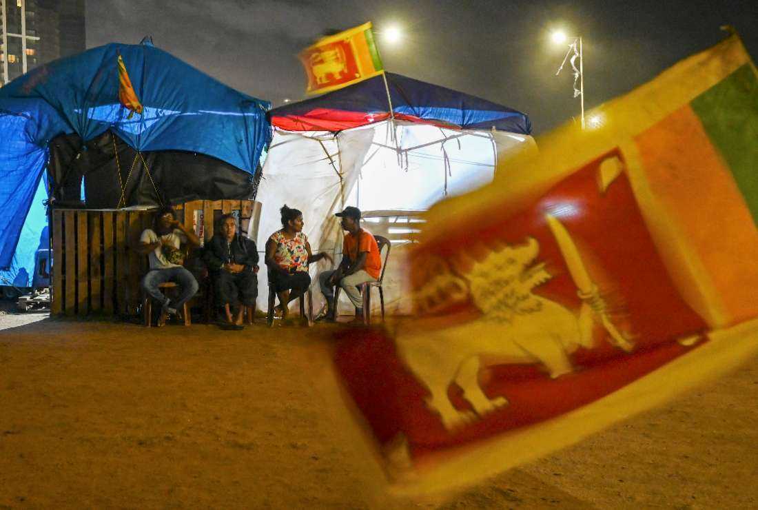 Protesters sit at their makeshift camp during an ongoing protest amid economic crisis near Presidential Secretariat in Colombo on Aug. 3