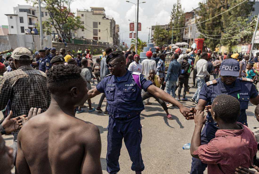 Congolese policemen try to prevent protesters from reaching the border between Democratic Republic of Congo and Rwanda during clashes with demonstrators in Goma on June 15