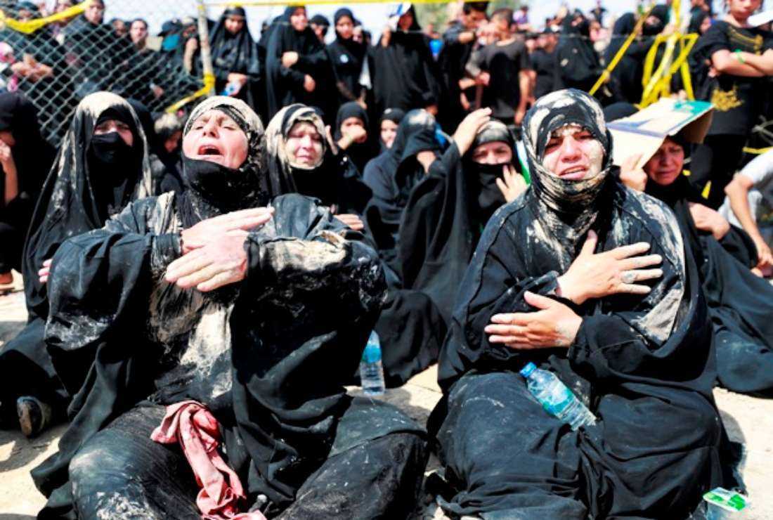 Iraqi Shiite Muslim women cry as they watch worshippers re-enacting the Battle of Karbala as they mark the peak of Ashura, a 10-day period commemorating the seventh century killing of Prophet Mohammed's grandson Imam Hussein, in Iraq's capital Baghdad on Aug. 9.