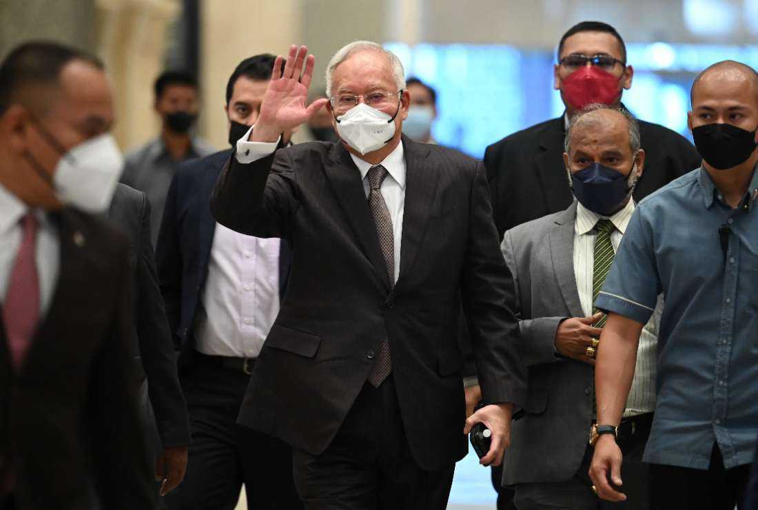 Malaysia's former prime minister Najib Razak (center) waves as he arrives at the federal court in Putrajaya on Aug. 18