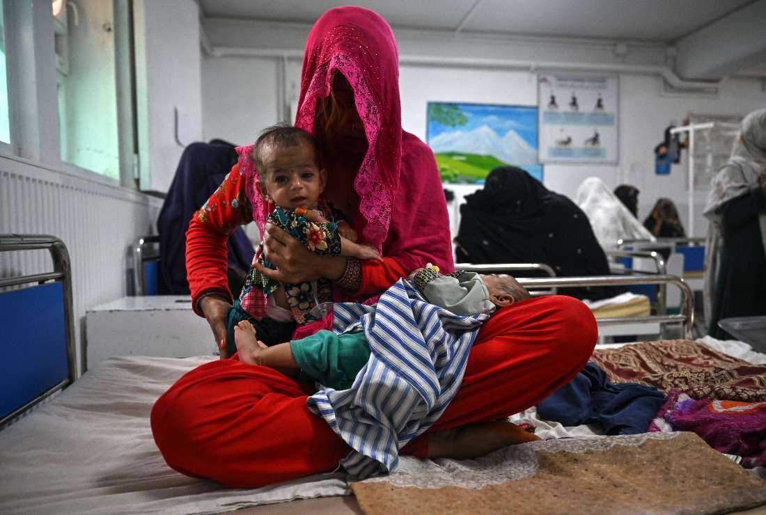 Breshna sits on a hospital bed with her four-month-old twins Subhania and Subhan in the malnutrition ward at the Boost Hospital, run by Medicines Sans Frontiers (MSF), in Lashkar Gah, Helmand, on July 21