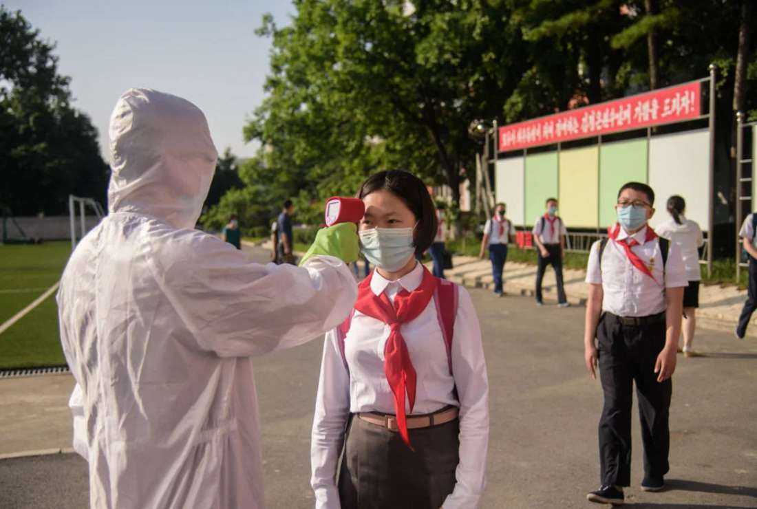 A student has her temperature taken as part of anti-Covid-19 procedures before entering a school in Pyongyang on June 22, 2021