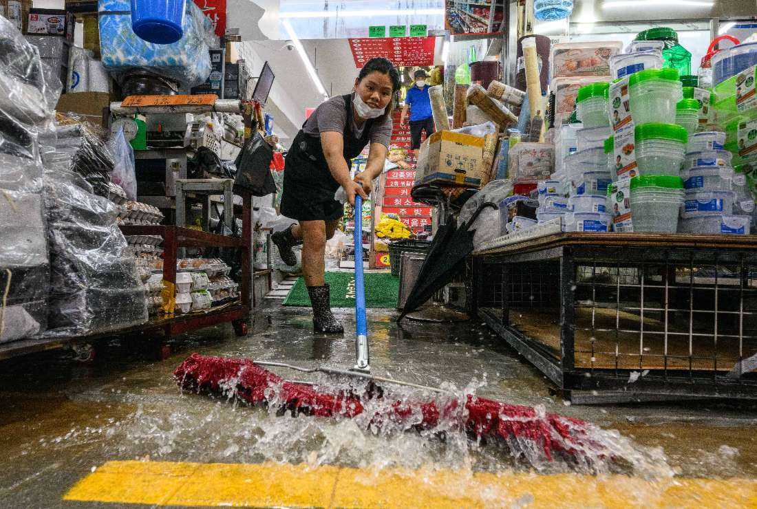 A worker clears water from her shop at the historic Namseong Market in the Gangnam district of Seoul on Aug. 9 after record-breaking rains caused severe flooding in parts of South Korea