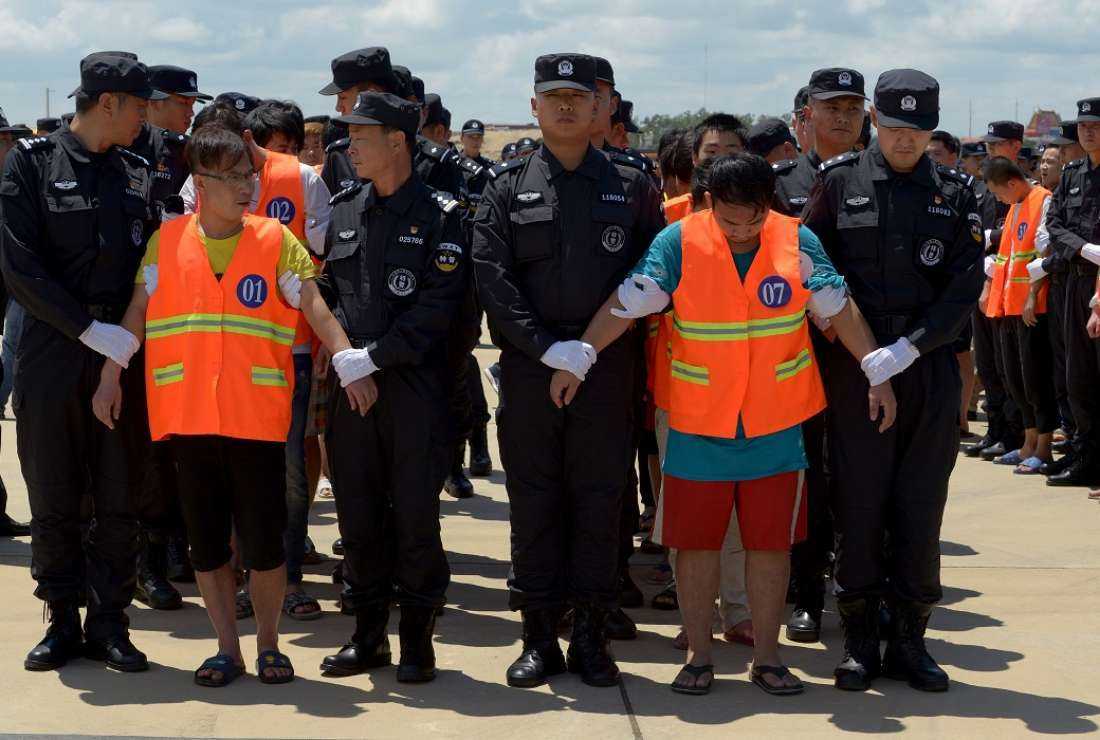 Chinese police escort suspects to a plane at Phnom Penh international airport in this Oct 12, 2017 file photo. Cambodia deported 74 Chinese nationals suspected of running a telecoms scam to extort money from victims in their home country