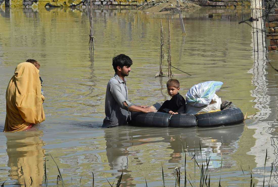 A family wades through a flood-hit area following heavy monsoon rains in Charsadda district of Khyber Pakhtunkhwa on Aug. 29