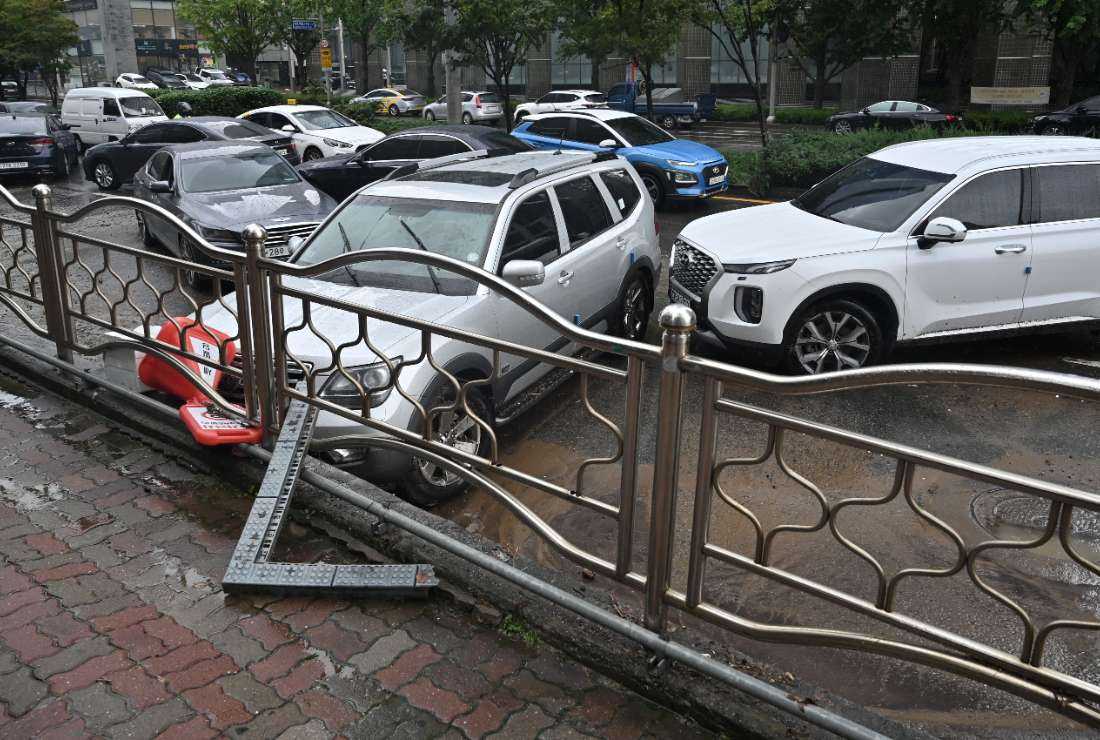 Cars damaged by flood water are seen on the street after heavy rainfall at Gangnam district in Seoul on Aug. 9