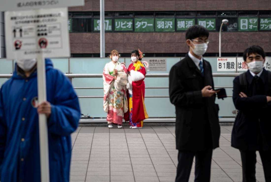 Two young women, dressed in traditional outfits to mark 'Coming-of-Age Day' when the country honors people who turn 20 to signify adulthood, stand outside a train station in Yokohama on Jan. 10