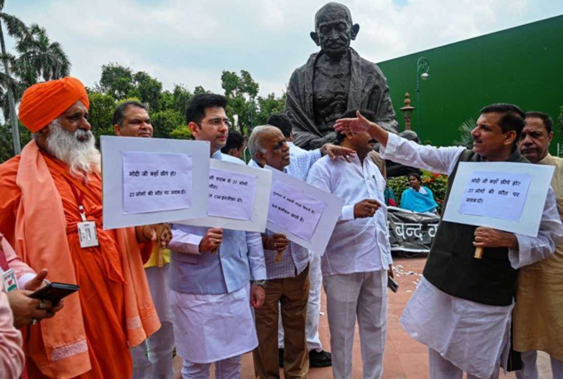 Indian lawmakers of the Aam Aadmi Party hold placards during a protest in New Delhi on July 26 against the Bharatiya Janata Party led-government after at least 24 people allegedly died due to consuming bootleg liquor in Gujarat state