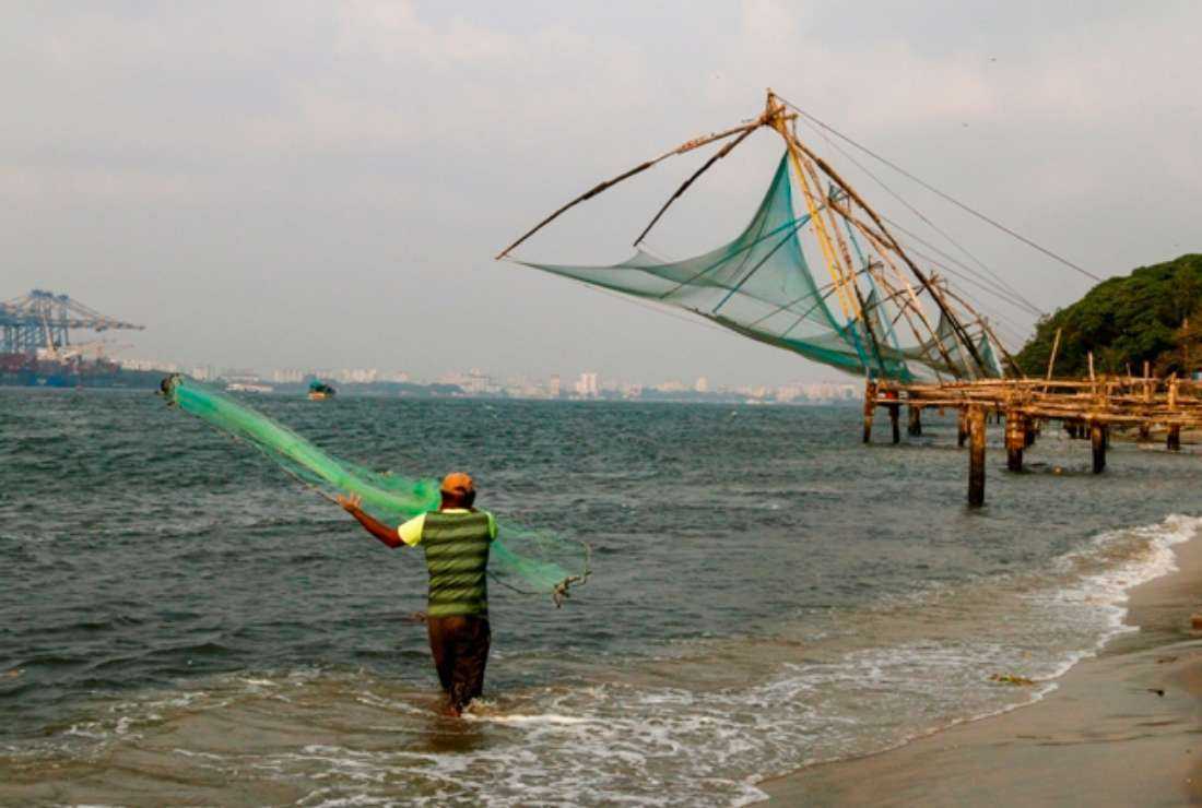 A fisherman casts his net on the shore of the Arabian Sea at Kochi in the southern Indian state of Kerala on March 18